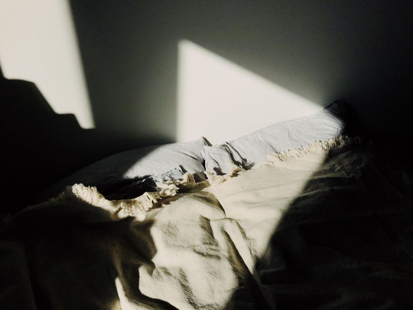 Morning light across a bed in a quiet room